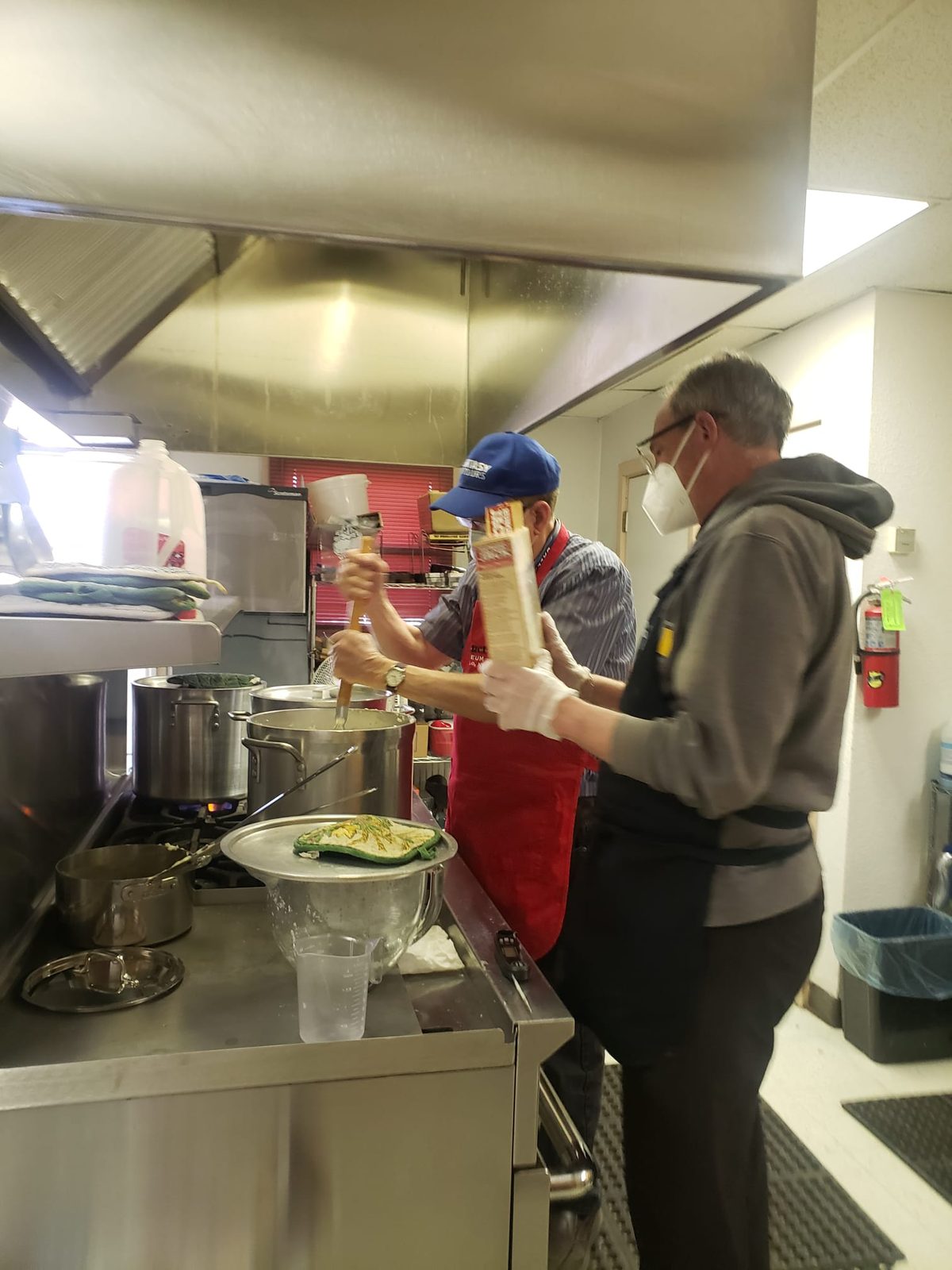 Volunteers preparing a large pot of soup in the Comedor kitchen